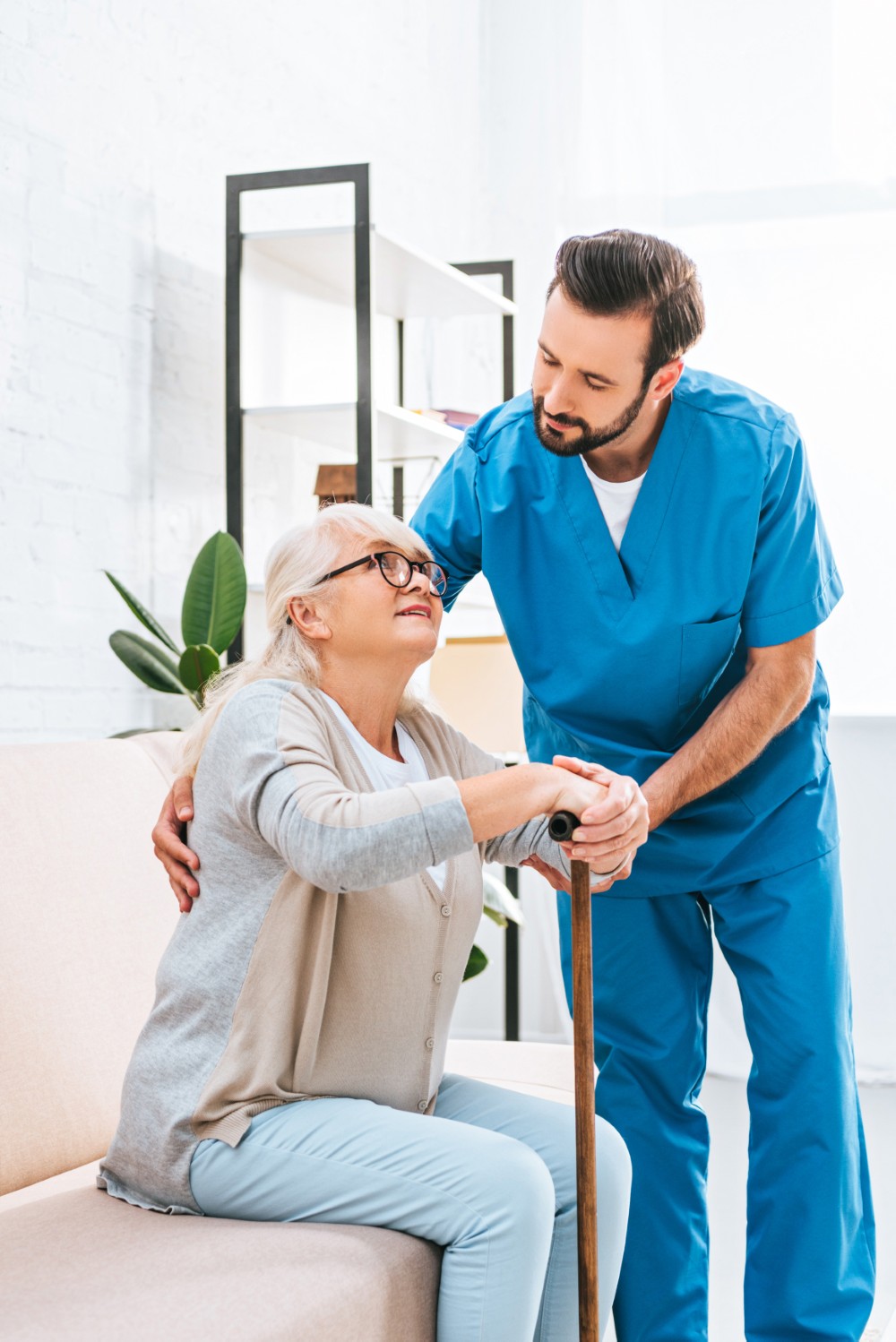 Male caregiver supporting a senior woman, representing Greys Home Care's dedicated care team in Connecticut